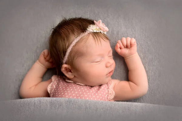 ピンクのスーツを着た可愛い新生児と 頭に蝶が描かれたピンクのヘッドバンドは 甘く眠ります 灰色の背景のプロのマクロ写真 — ストック写真