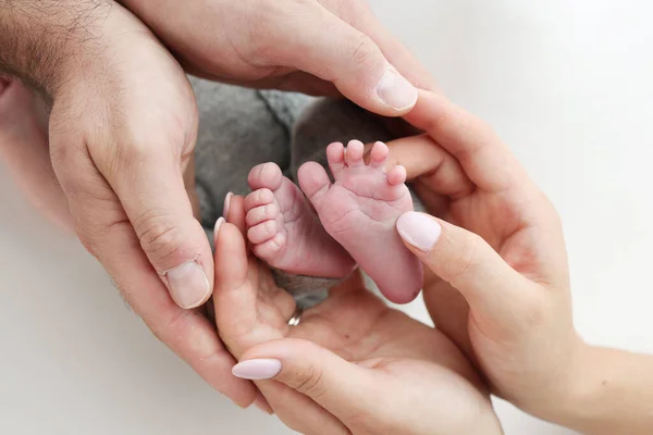 Ладони Отца Мать Держат Ногу Новорожденного Ребенка Белом Фоне Ноги — стоковое фото