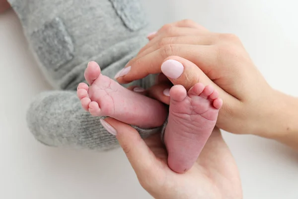 父親の手のひらは 母親が白い背景に新生児の足を保持している 両親の手のひらに新生児の足 子供のつま先 かかとと足の写真 — ストック写真