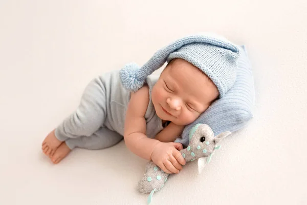 Roztomilý Novorozenec Prvních Dnech Života Spí Modré Kombinéze Pozadí Bílé — Stock fotografie
