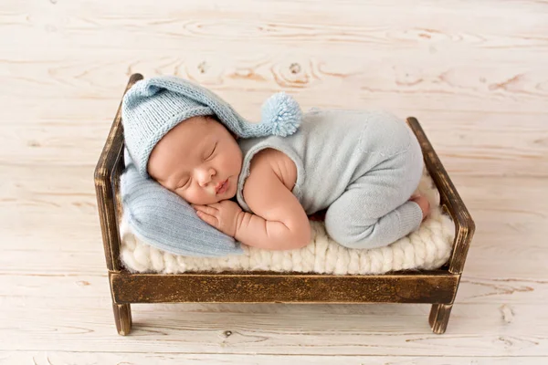 Roztomilý Novorozenec Prvních Dnech Života Spí Modré Kombinéze Dřevěné Hnědé — Stock fotografie
