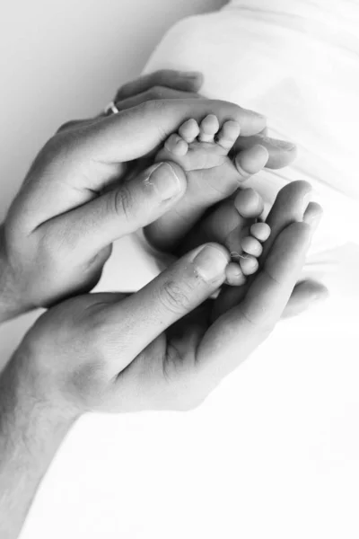 父亲的手掌 母亲用白色的背景抱着新生儿的脚 新生儿的脚踏在父母的手掌上 小孩的脚趾 脚跟和脚的摄影 — 图库照片