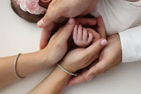 stock image Small hand of a newborn baby with tiny fingers, head, nose and ear of a newborn. Palm hand of parents, father and mother of a newborn. Studio macro photography. 