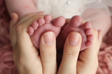 Anne bebek ayağına masaj yapıyor. Bebek ayaklarını annenin ellerine teslim et. Düz taban, gelişim, kas yapısı, displazi. Aile, sevgi, ilgi ve sağlık kavramları. Stüdyo makrosu. 