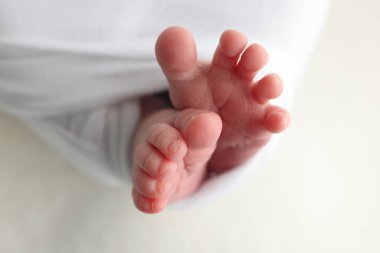 Yeni doğmuş bir bebeğin ayağı. Ayaklarını, ayak parmaklarını, topuklarını, yeni doğmuş bir bebeğin ayaklarını kapat. Stüdyo monokromu, vintage tarzı, siyah beyaz makro fotoğraf. 