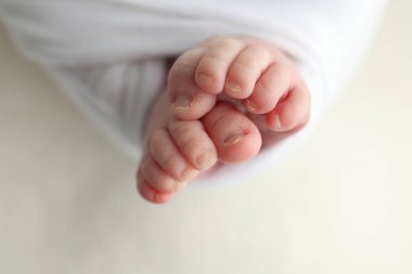 Yeni doğmuş bir bebeğin küçük ayağı. Beyaz battaniyeli yeni doğmuş bir bebeğin yumuşak ayakları. Yeni doğmuş bir bebeğin ayak parmaklarını, topuklarını ve ayaklarını kapat. Stüdyo Makro fotoğrafçılık. Kadınların mutluluğu. 