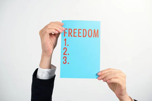 Text sign showing Freedom, Business showcase power or right to act speak or think as one wants without hindrance Businesswoman Holding Note With Important Message With Both Hands.