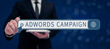 Adwords Kampanyası, iş dünyası vitrininde, takım elbiseli bir işadamının elinde başarılı takım çalışmasını simgeleyen tablet tutarak her yerde ve her an bir şeyler yapabileceğini söyleyen bir tablet..