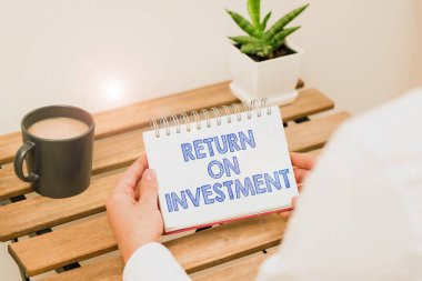 Yatırım Dönüşü 'nü gösteren metin başlığı, finansal bir raporu veya yatırım risk analizini inceleyen kavramsal fotoğraf