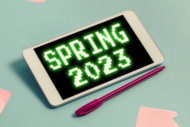 İlkbahar 2023 'ü gösteren tabela, kış mevsiminden sonra çiçeklerin yükseldiği yılın iş gösterisi zamanı.