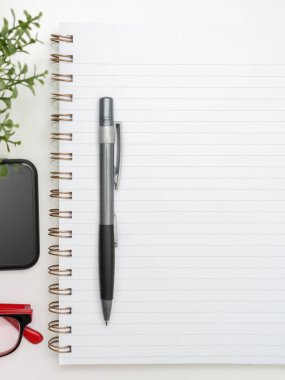Notebook With Important Messages On Desk With Coffee, Phone And Pen.