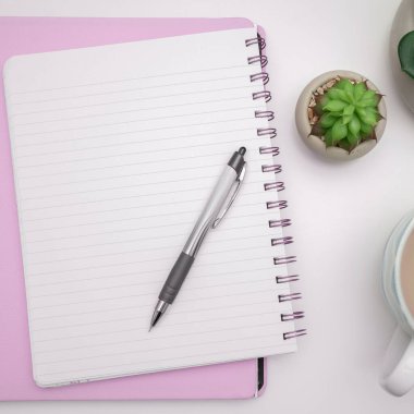 Pot with Plant and Cup Standing on Desk. Iinfrormation written on paper.