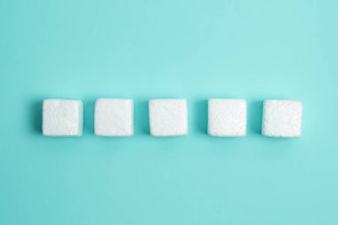 White Styrofoam Cubes Lying on Coloured Desk. Brand new Information.