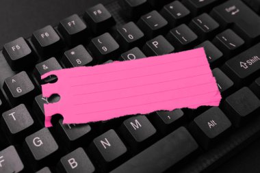 Sticker lying on black keyboard. Important message written over paper.