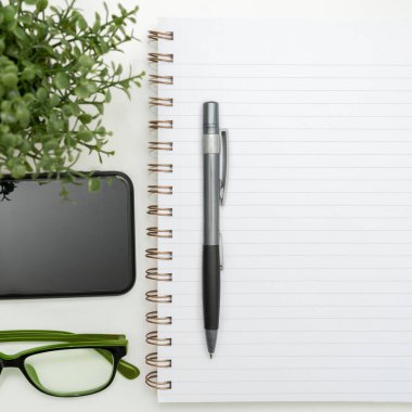 Notebook With Important Messages On Desk With Coffee, Phone And Glasses.