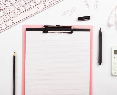 Paper with important text near keyboard. Information written on notebook.