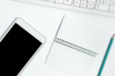 Notebook With Important Messages On Desk With Coffee, Phone And Pen.