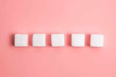 White Styrofoam Cubes Lying on Coloured Desk. Brand new Information.