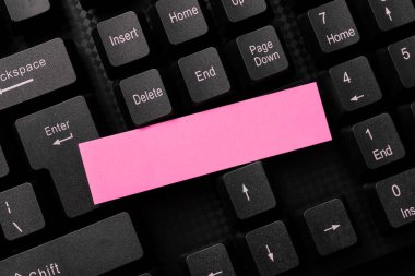 Sticker lying on black keyboard. Important message written over paper.