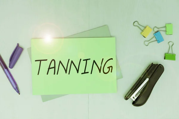 Text sign showing Tanning, Word for a natural darkening of the scin tissues after exposure to the sun