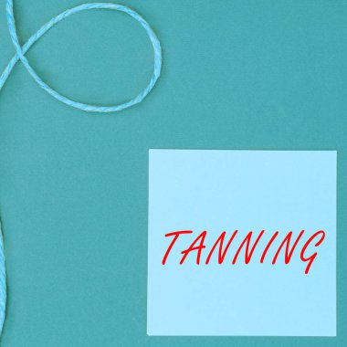 Bronzlaştığını gösteren tabela, güneşe maruz kaldıktan sonra deri dokularının doğal olarak karardığını gösteriyor.