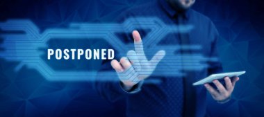 Sign displaying Postponed, Business showcase to place later in order of precedence, preference, or importance