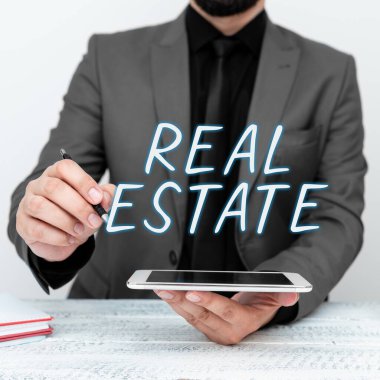 Gayrimenkul 'ü gösteren bir tabela. Arazi ve binalardan oluşan araziye yazılmış bir söz.