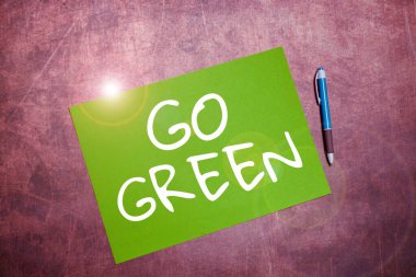 Go Green 'i gösteren tabela, geri dönüşümü azaltmak için çevre dostu kararlar veren iş vitrini