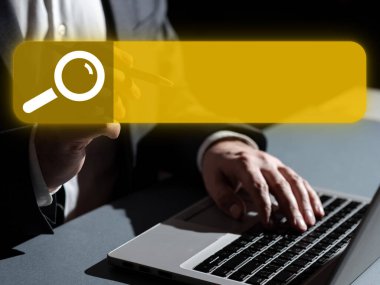Man in office suit sitting at the table with lap top and typing text.