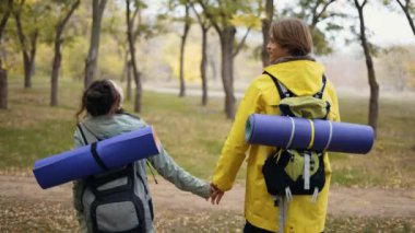 Tanımlanamayan çiftler ormanda el ele yürüyorlar..