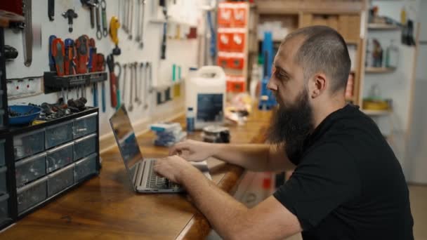 Kaukasische Meester Met Behulp Van Laptop Fiets Workshop Het Kiezen — Stockvideo