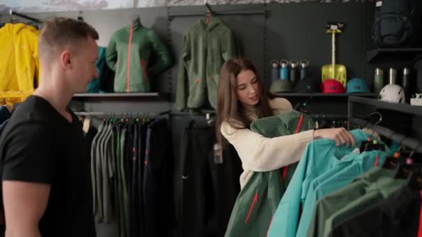 Girl Store Asks Guys Advice Choosing Two Sport Jackets — Vídeos de Stock