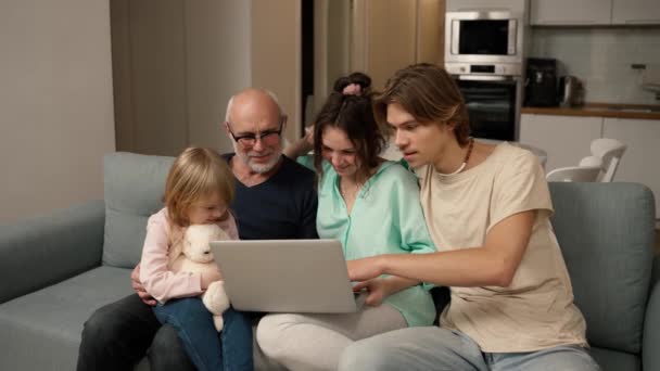 子供たちとおじいちゃんはノートパソコンを使いながら一緒に笑っています — ストック動画