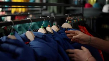 Man chooses sports clothes in a store shopping mall.