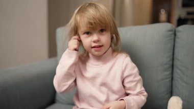 Little funny girl trying to wear ear plugs taking out her earphones.