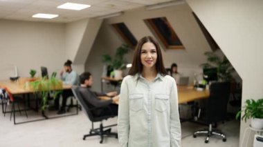 Smiling caucasian girl standing at modern office coworking space.