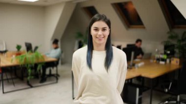 Smiling modern girl standing at modern office coworking space.