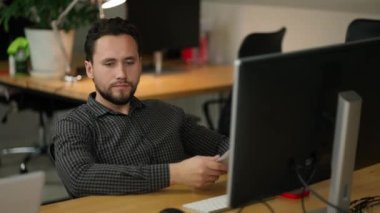 Portrait of focused professional typing on pc keyboard indoors at office.