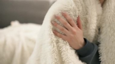 Female hand touching the fur blanket white color.
