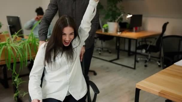 Excited Cheerful Colleagues Having Fun Riding Office Chair Coworking Space — Vídeo de stock