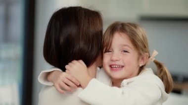 Little kid girl hugging mother, adorable small child daughter embrace mum cuddling enjoy tender sweet moment.