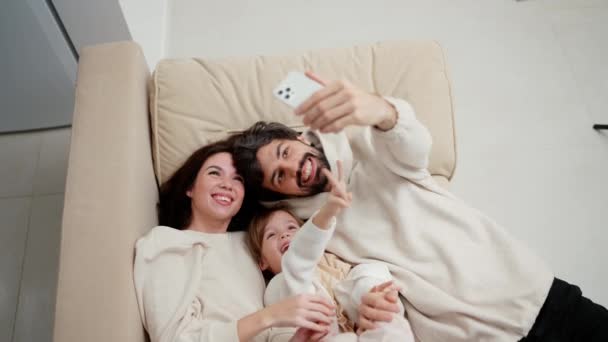 Young Family Making Selfie Posing While Laying Sofa Living Room — Video