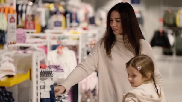 Mutter Und Tochter Gehen Mit Mädchen Einkaufswagen Durch Ein Bekleidungsgeschäft — Stockvideo
