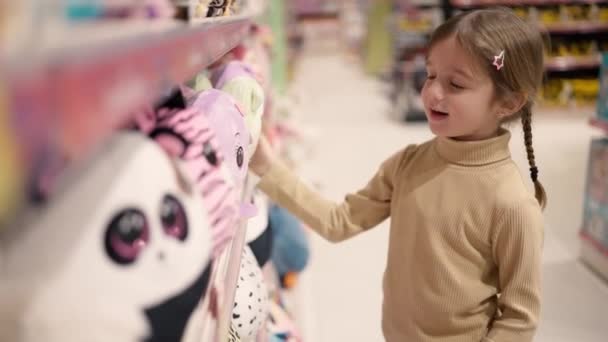 Girl Standing Childrens Toy Store Front Shelf Take Soft Toy — Vídeo de Stock