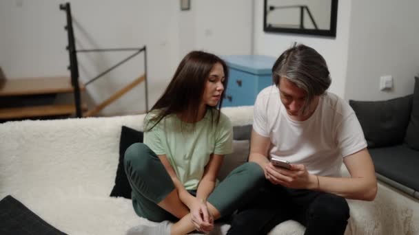 Ζευγάρι Κάθονται Μαζί Στο Κρεβάτι Ένας Άνθρωπος Χρησιμοποιούν Συσκευή Smartphone — Αρχείο Βίντεο