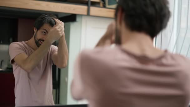 Schöner Junger Mann Kämmt Haare Spiegel Setzt Kopfhörer Auf Und — Stockvideo