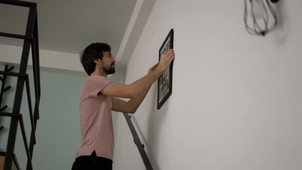 Ένας Άντρας Κρεμασμένος Στον Τοίχο Στο Νέο Σπίτι — Αρχείο Βίντεο