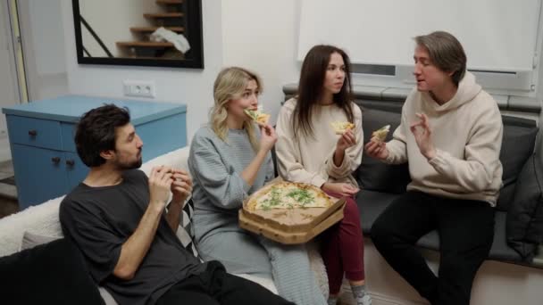 2回デート 幸せな男性と女性の友人食べるおいしいピザ上のソファ — ストック動画