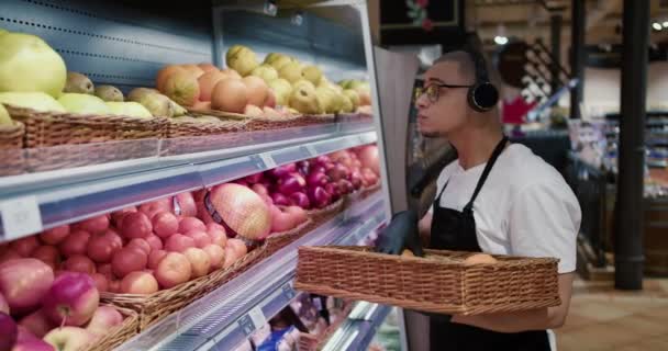 Homem Trabalhador Avental Preto Luvas Meia Frutas Supermercado Enquanto Ouve — Vídeo de Stock