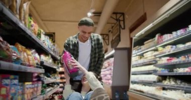 Genç çift eğleniyor, adam alışveriş arabasını kız arkadaşıyla birlikte itiyor..